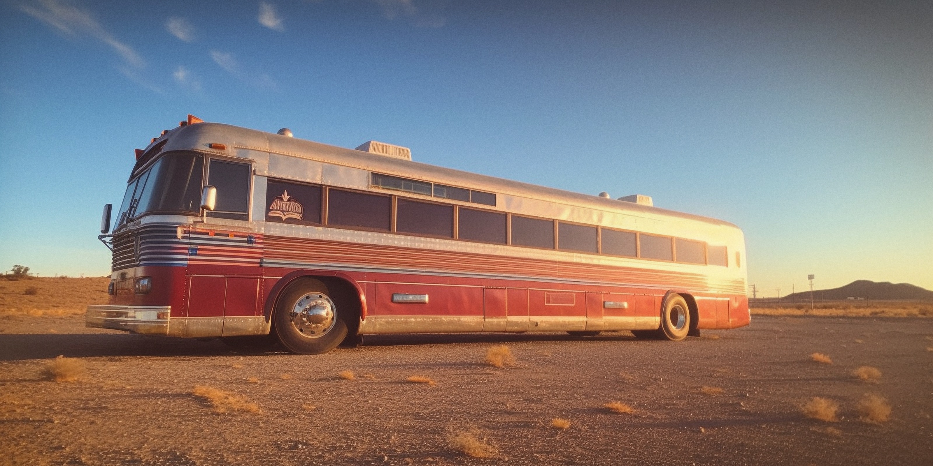A vintage tour bus in the desert.